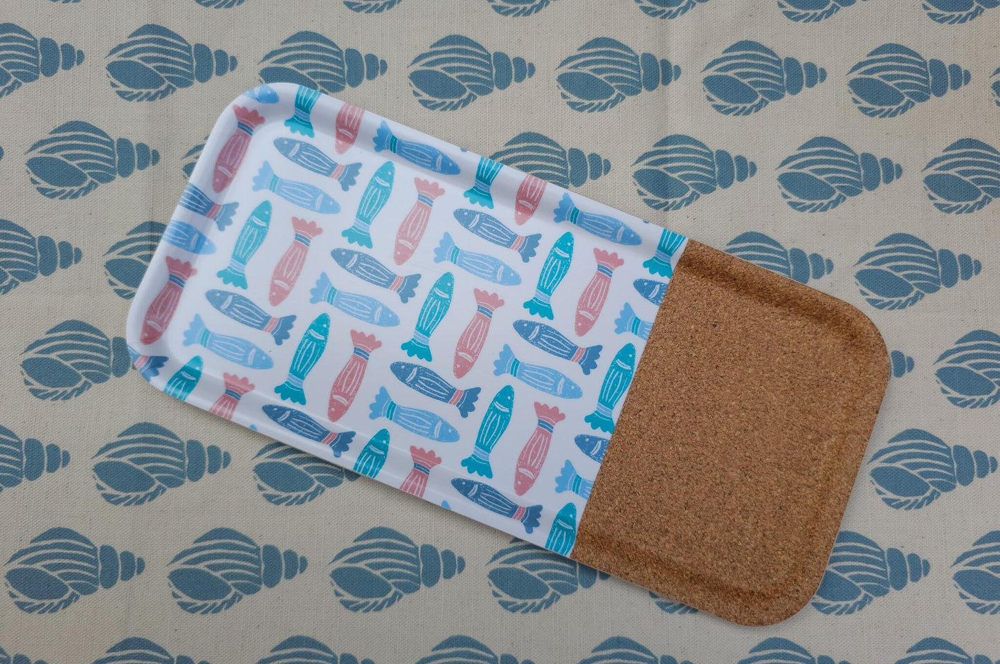 ZIA LIVING rectangular serving tray featuring a colourful fish pattern with a natural cork section, displayed on a shell fabric backdrop