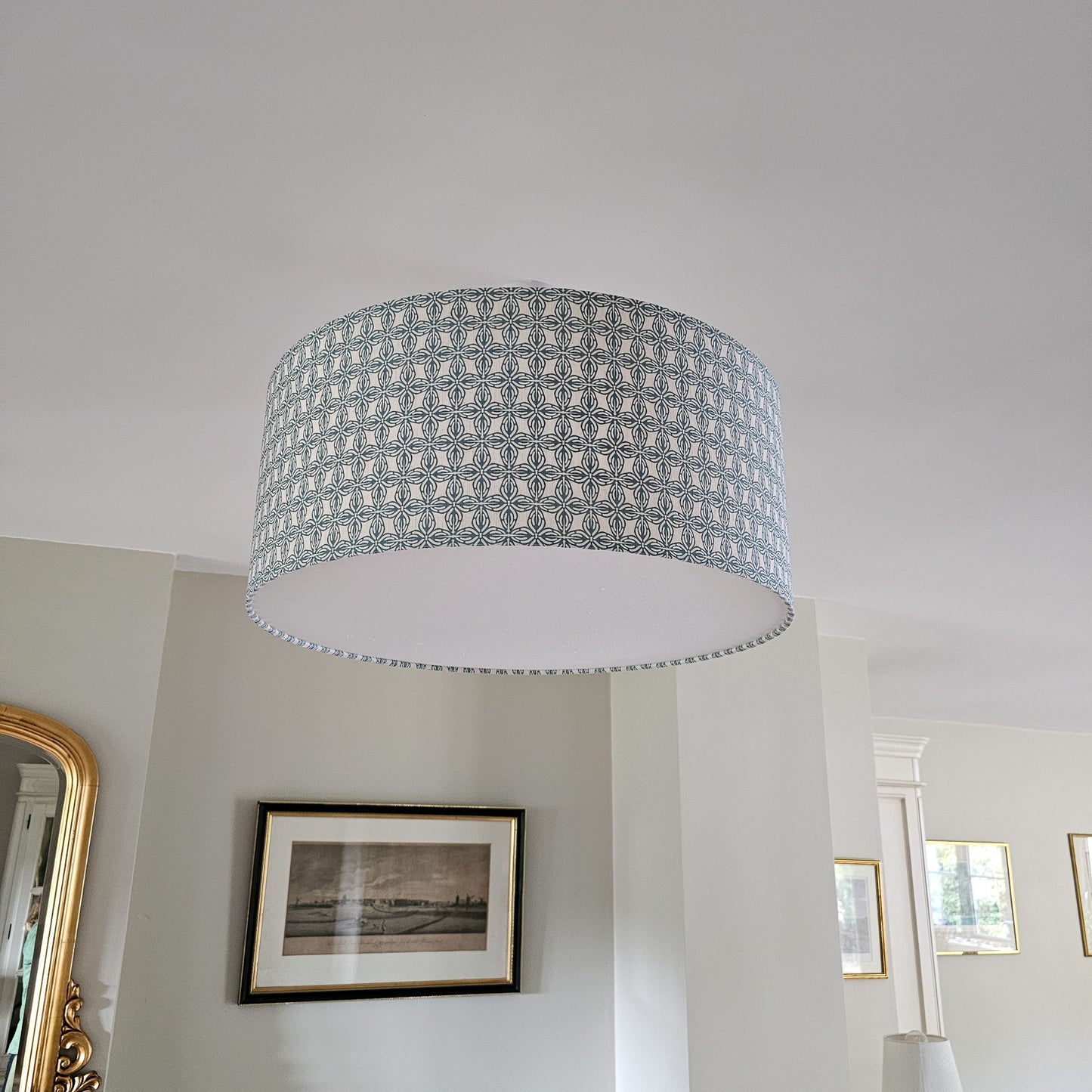 Ceiling shade in Bella pattern from Zia Living in Blue and White with diffuser with framed pictures on the wall.