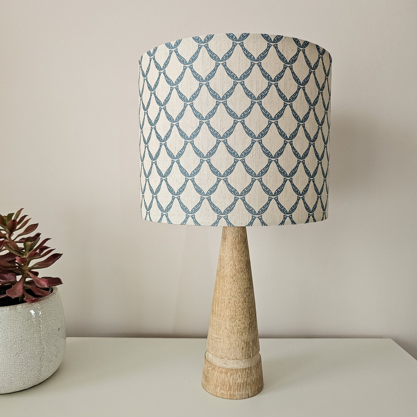Marina cotton linen fabric featuring an interlocking curved blue lattice pattern on an off‑white background., featured on a lampshade ZIA LIVING