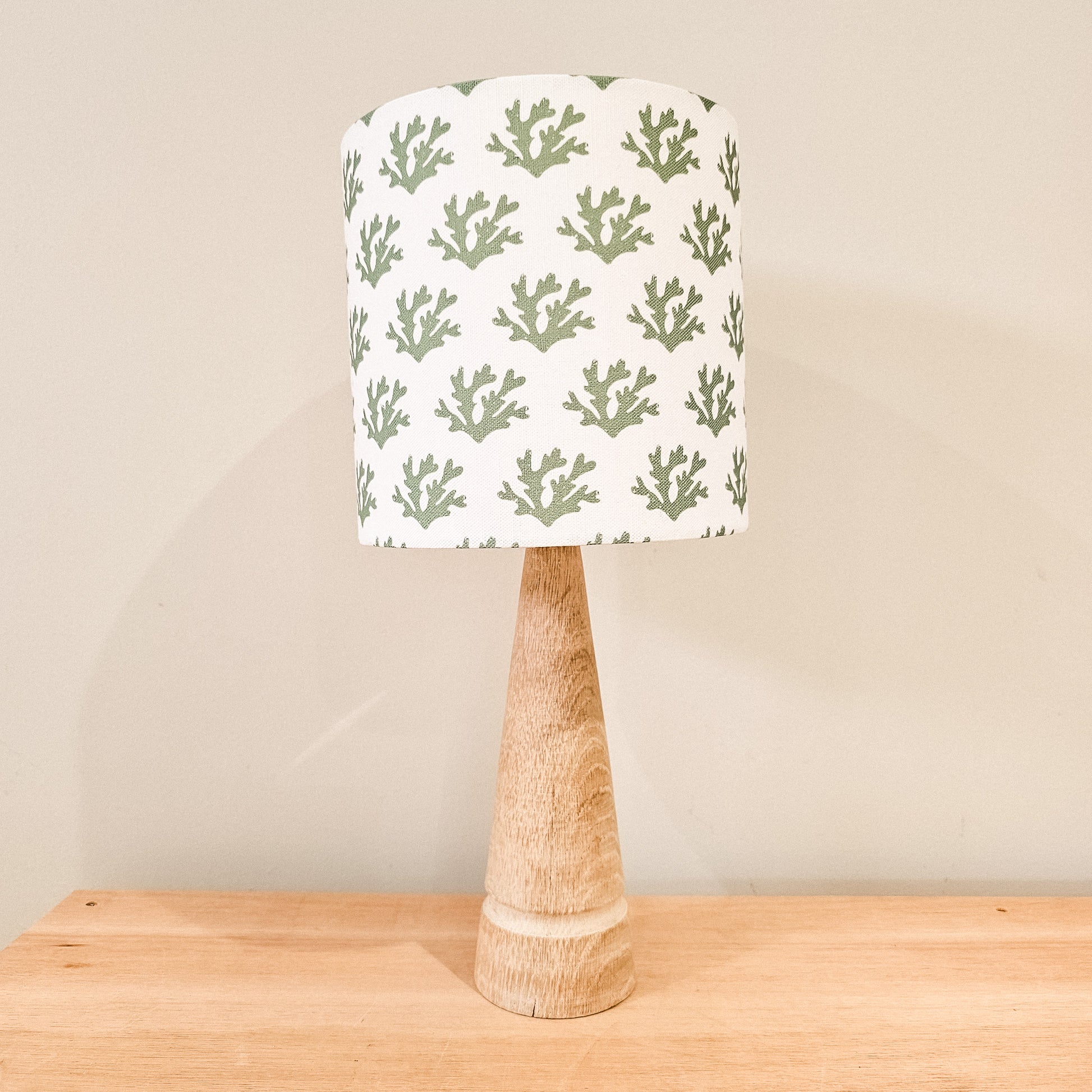 Handmade drum lampshade in green seaweed print fabric on a wooden lamp base, with neutral wall background— artisan home décor by ZIA LIVING
