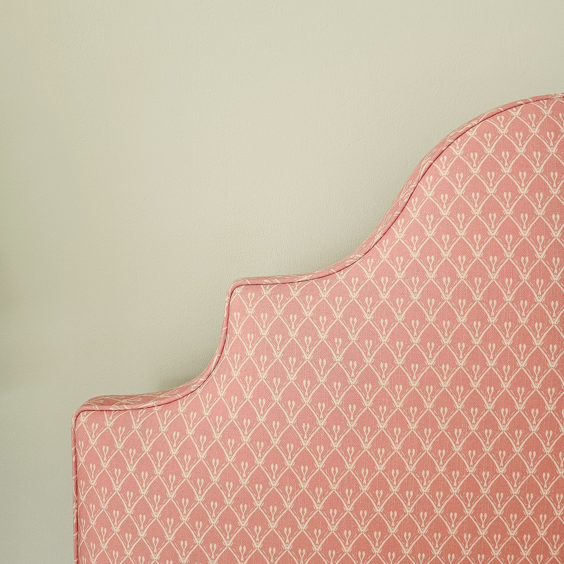 Pink trellis‑style lino print on cotton‑linen fabric with a natural textured background featured on a headboard— ZIA LIVING.