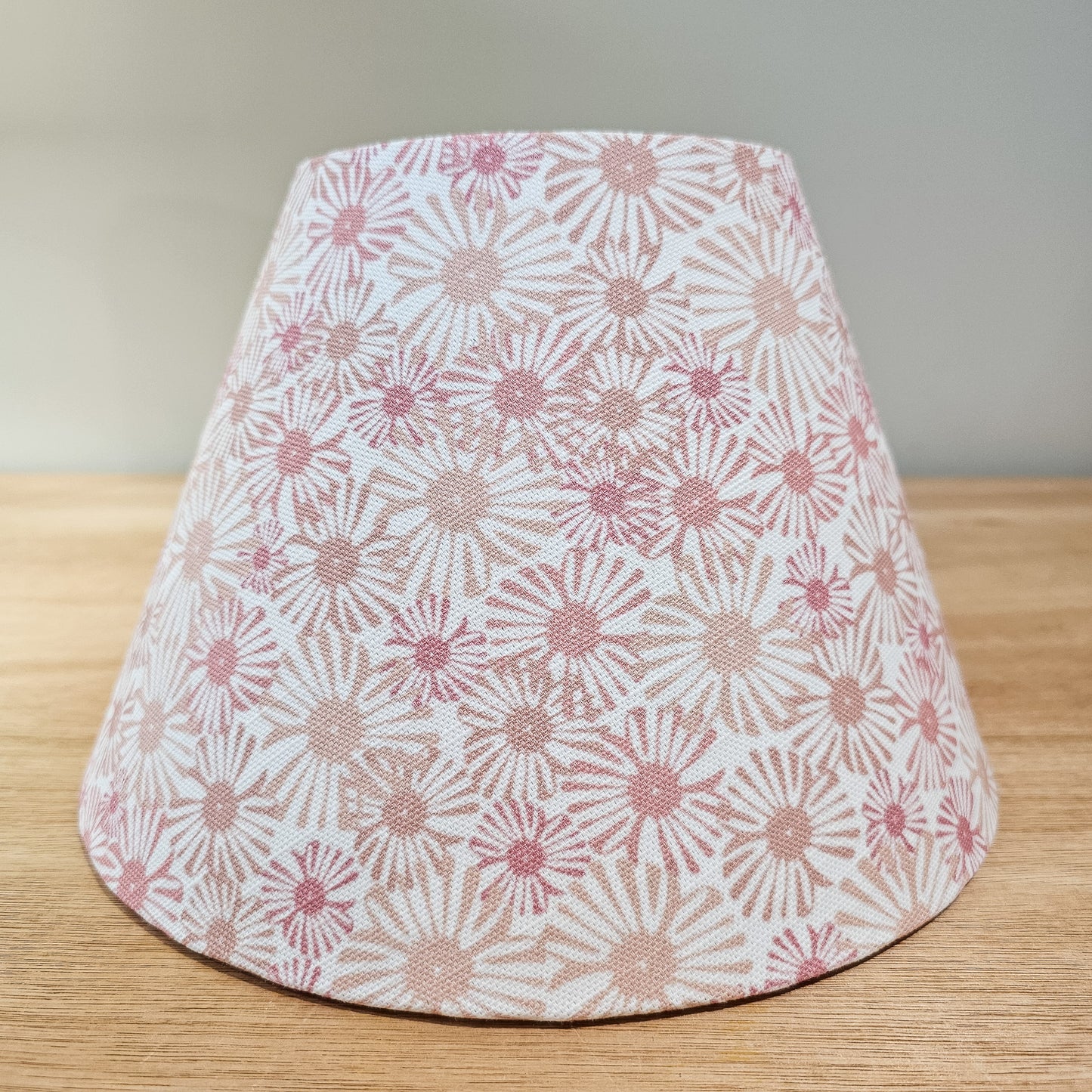 Handmade conical lampshade in Pink Daisy floral fabric on a wooden surface — artisan home décor by ZIA LIVING.