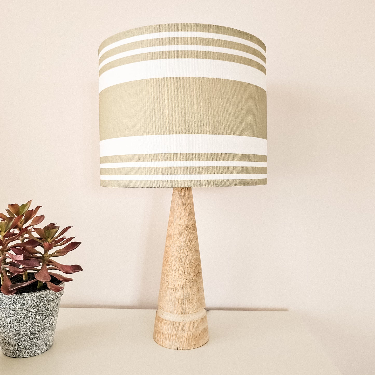 Handmade drum lampshade in Harbour Stripe mink colour fabric on a wooden lamp base, styled with a small succulent — artisan home décor by ZIA LIVING.