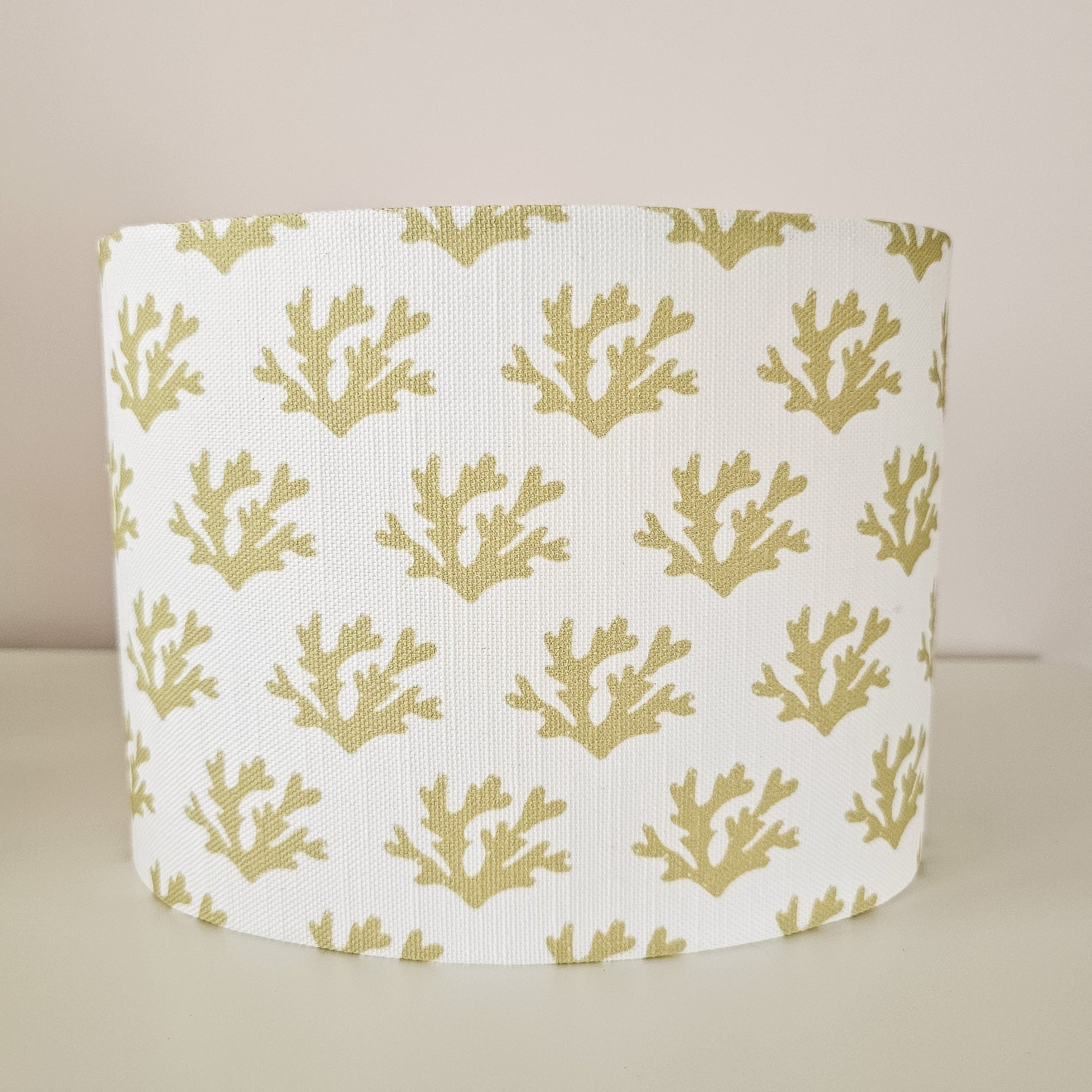 Seaweed motif lampshade by ZIA LIVING, featuring a repeating sand coloured sea‑coral pattern on a white cotton‑linen oval shade. Front view.