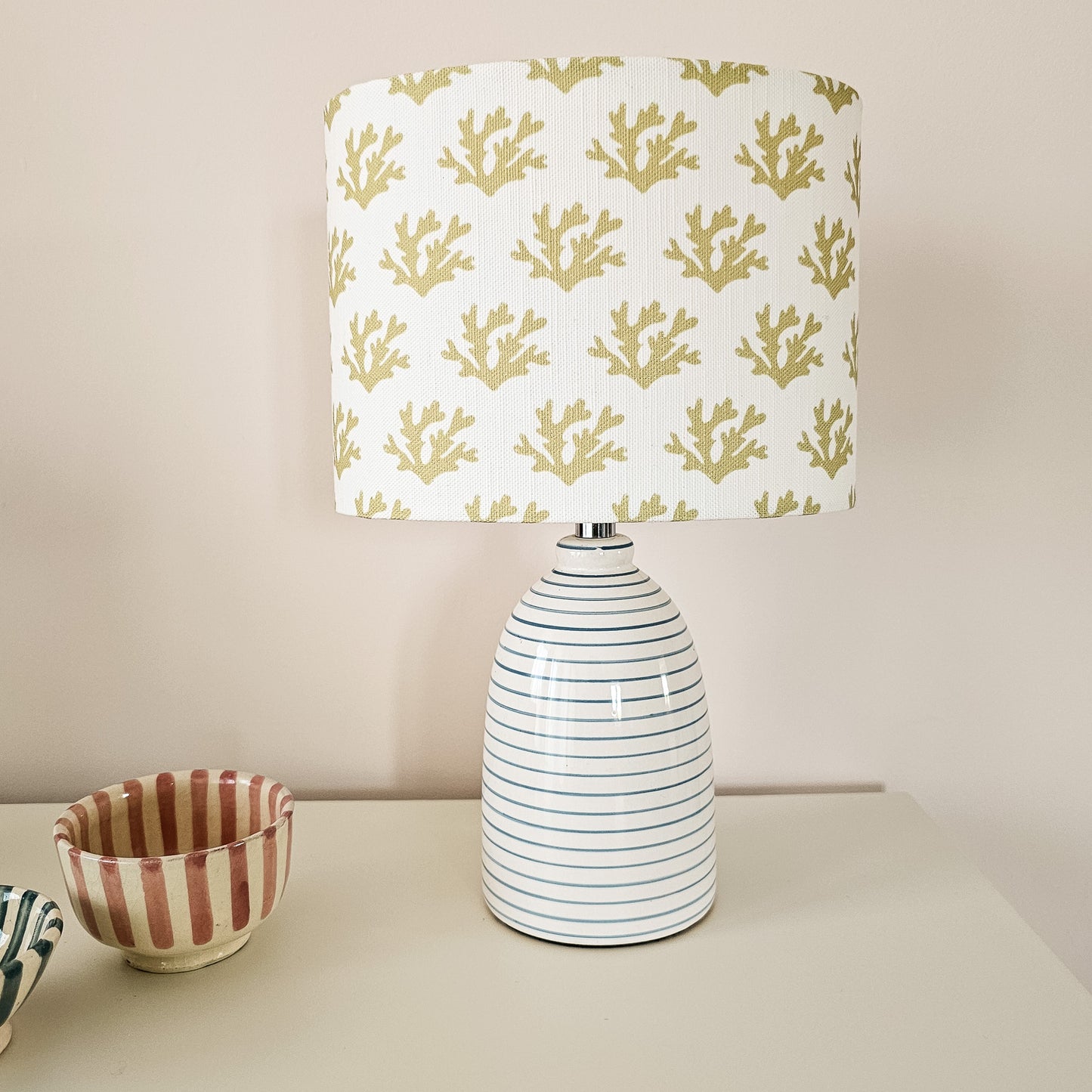 Seaweed motif lampshade by ZIA LIVING, featuring a repeating sand coloured sea‑coral pattern on a white cotton‑linen oval shade. Featured on a small white lampbase