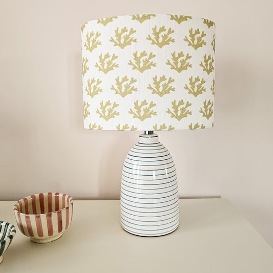 Seaweed motif lampshade by ZIA LIVING, featuring a repeating sand coloured sea‑coral pattern on a white cotton‑linen oval shade. Featured on a small white lampbase