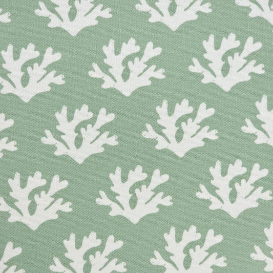 Seaweed cotton linen fabric featuring white lino print seaweed motifs in a repeating coastal pattern on a soft green background. ZIA LIVING.