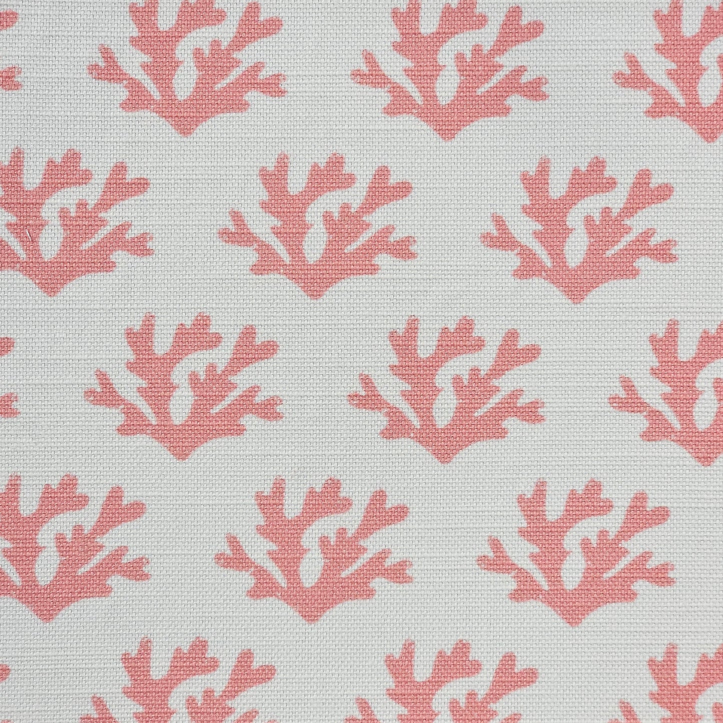 Green Seaweed cotton linen fabric featuring coral coloured hand carved lino print seaweed motifs in a repeating coastal pattern on a soft white background. ZIA LIVING.