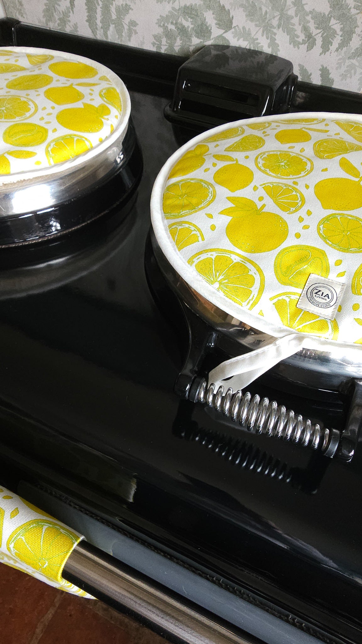 Lemon print round aga hob cover by ZIA LIVING, featuring bright yellow citrus fruit motifs on cotton, with ties on aga top
