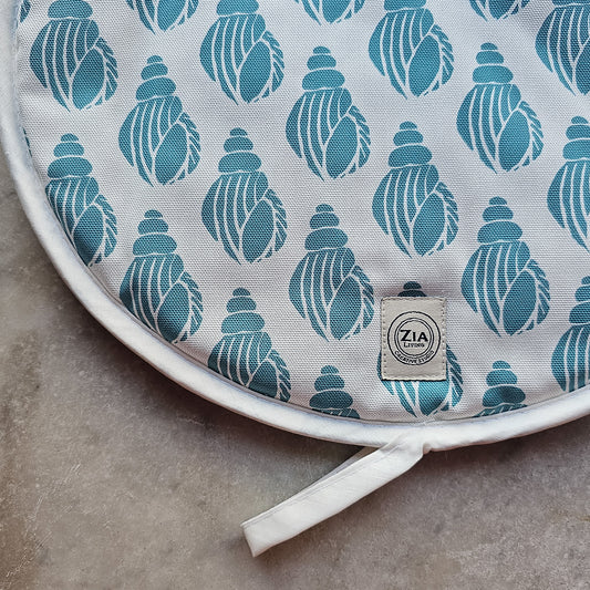 A single blue Shell aga pad from ZIA LIVING laid on a marble worktop, showing the detail