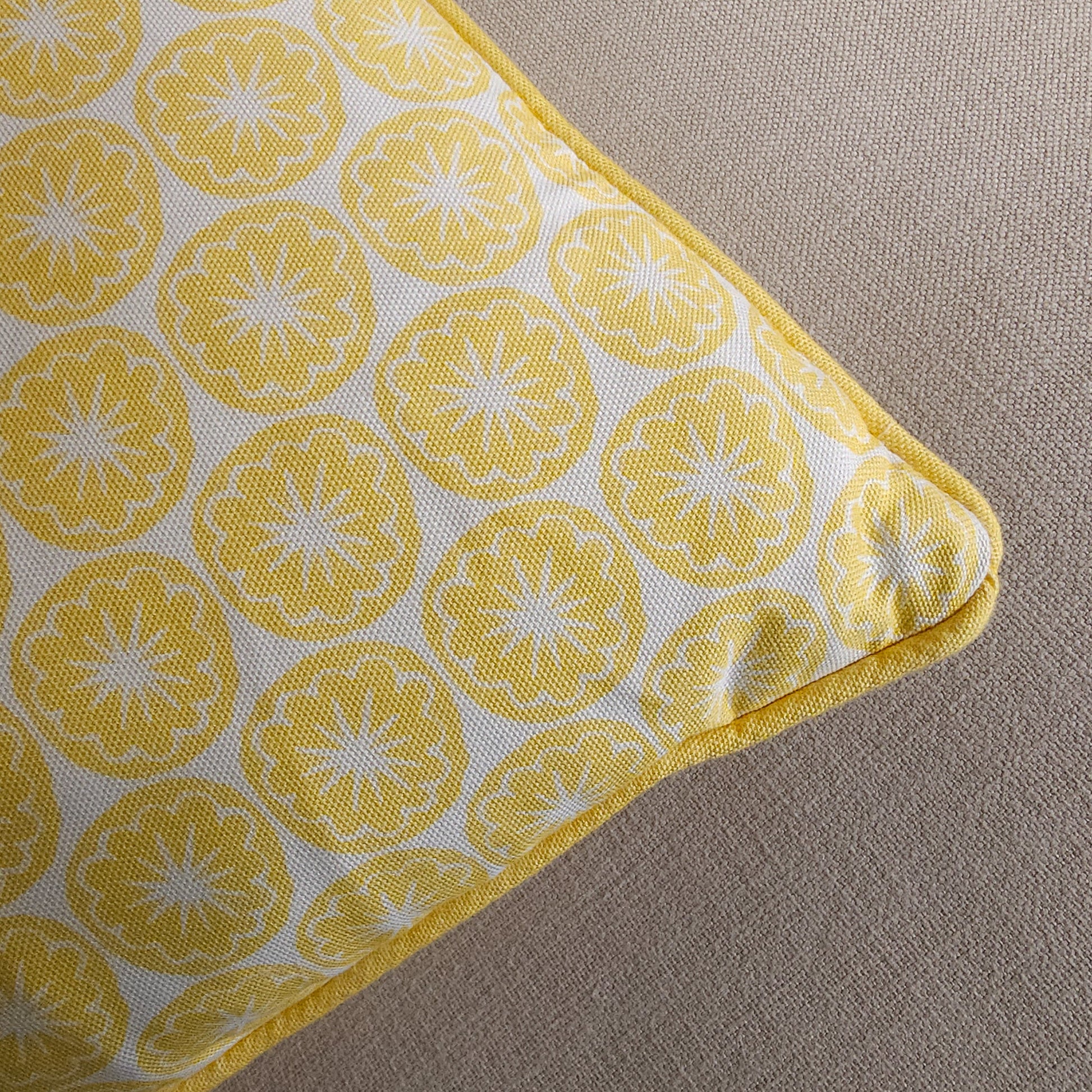 Yellow Seedhead patterned cushion, featuring bold circular yellow botanical motifs on a white background, close up— ZIA LIVING