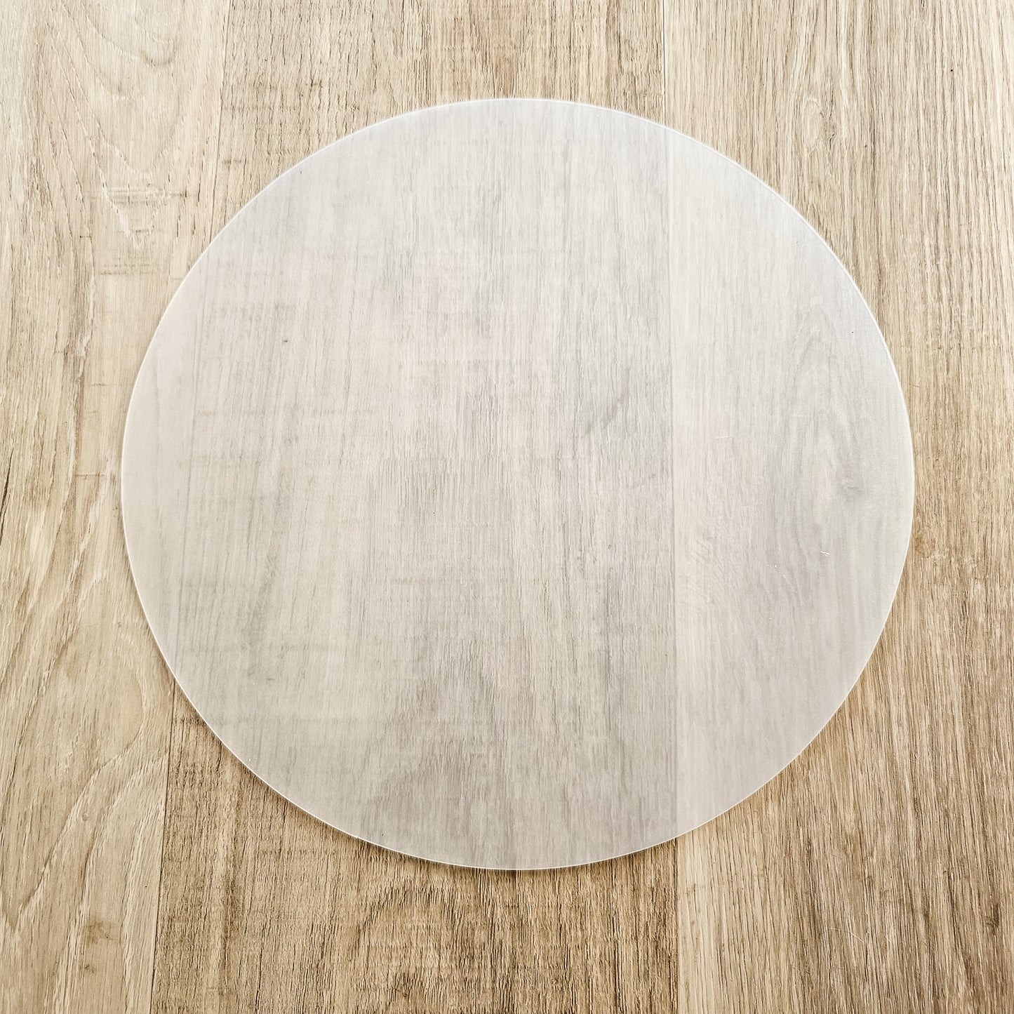Round lampshade diffuser laid flat on a wooden surface, showing its smooth translucent finish and circular shape — ZIA LIVING
