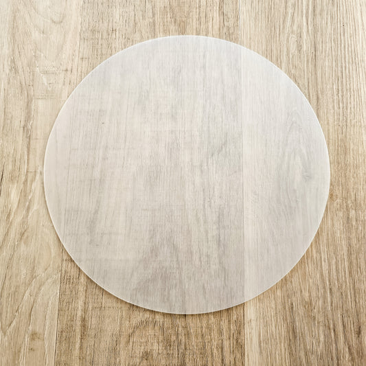 Round lampshade diffuser laid flat on a wooden surface, showing its smooth translucent finish and circular shape — ZIA LIVING