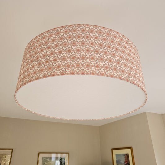 Ceiling shade in Stella pattern from Zia Living in Peach and White with diffuser with framed pictures on the wall.