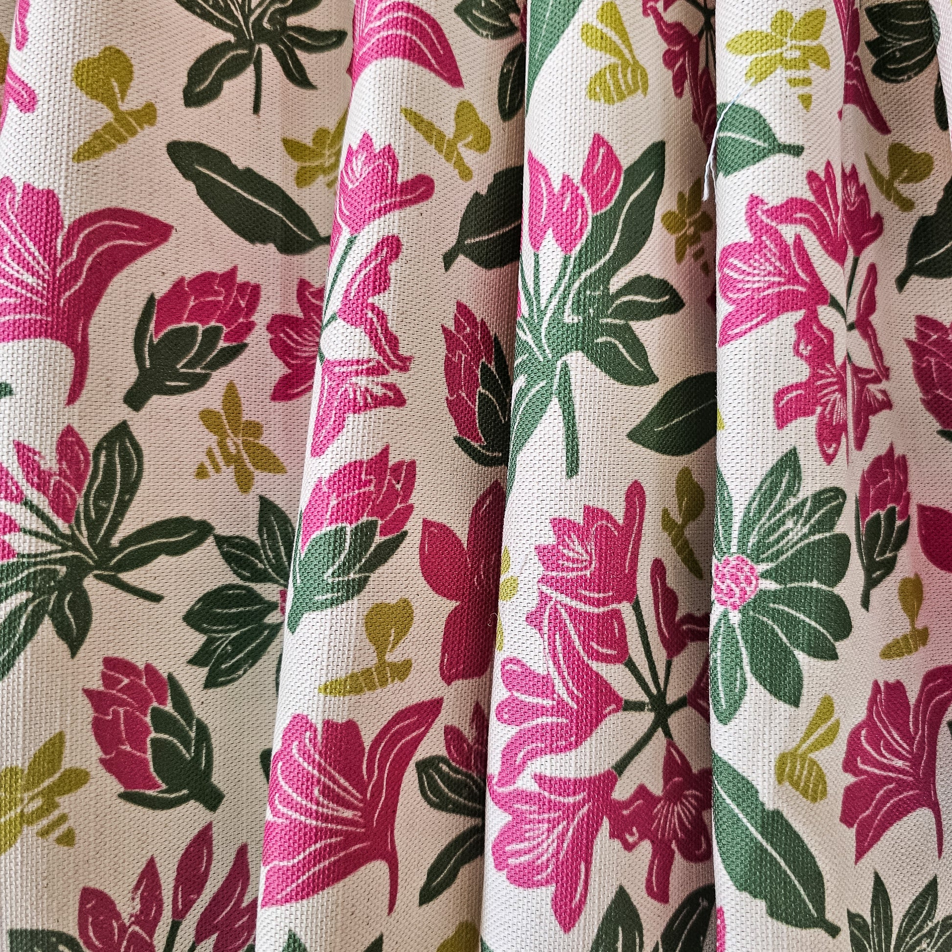 Floral rhododendron fabric pattern with pink and green flowers on a beige background, featured as draped fabric - Zia Living 