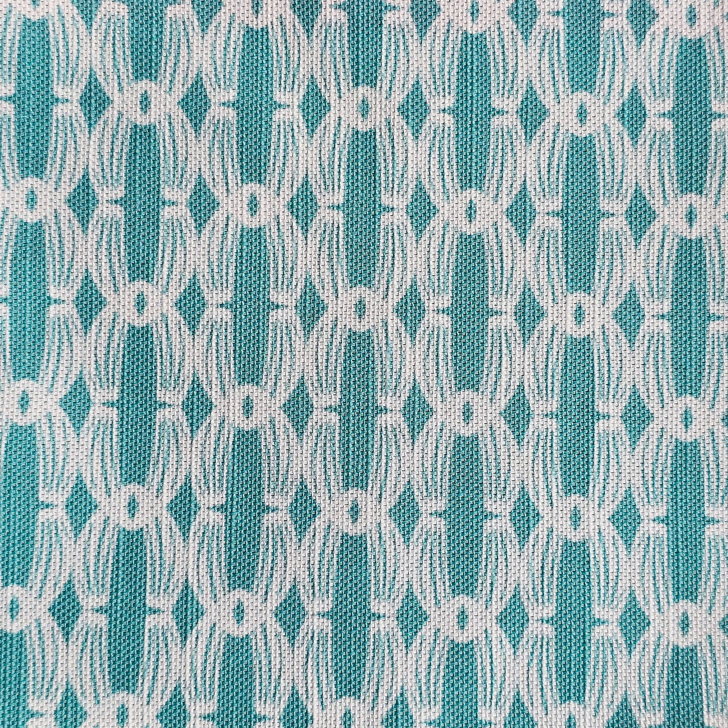 Close‑up of ZIA LIVING’s Anello cotton‑linen fabric in lapwing and white, showing its interlocking oval and diamond geometric weave pattern and textured artisan finish.