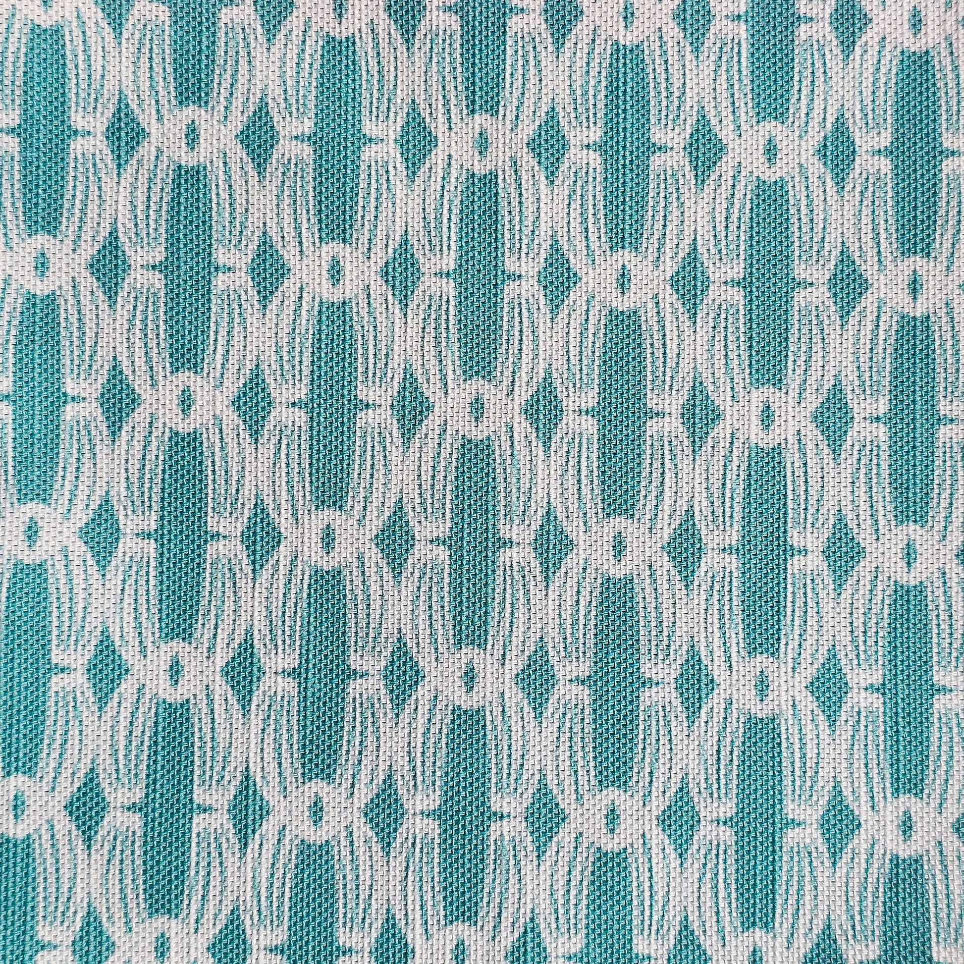 Close‑up of ZIA LIVING’s Anello cotton‑linen fabric in lapwing and white, showing its interlocking oval and diamond geometric weave pattern and textured artisan finish.