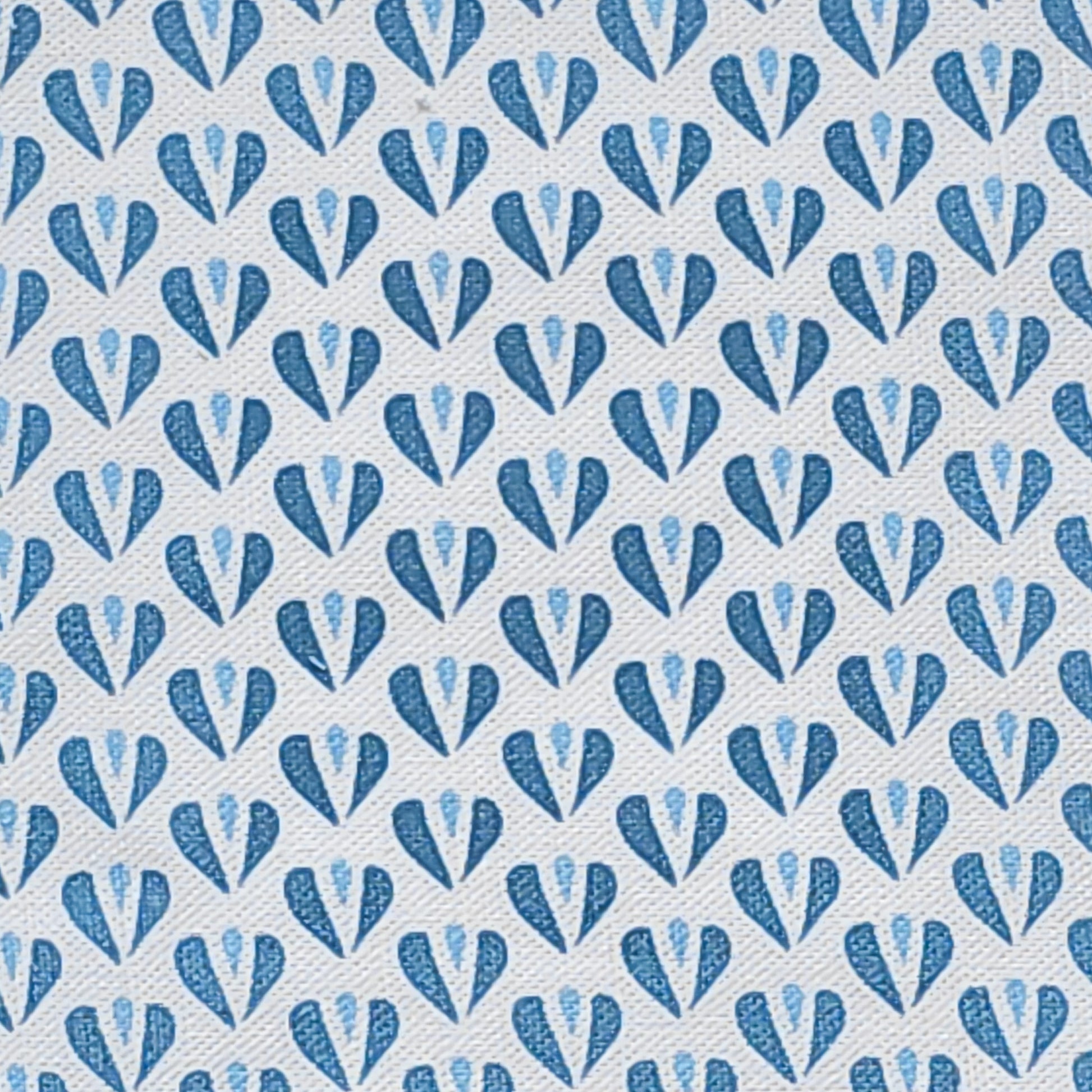 Carina, a heart motif patterned fabric by ZIA LIVING, featuring repeating blue and sky blue stylised heart shapes on a white textured cotton‑linen background.