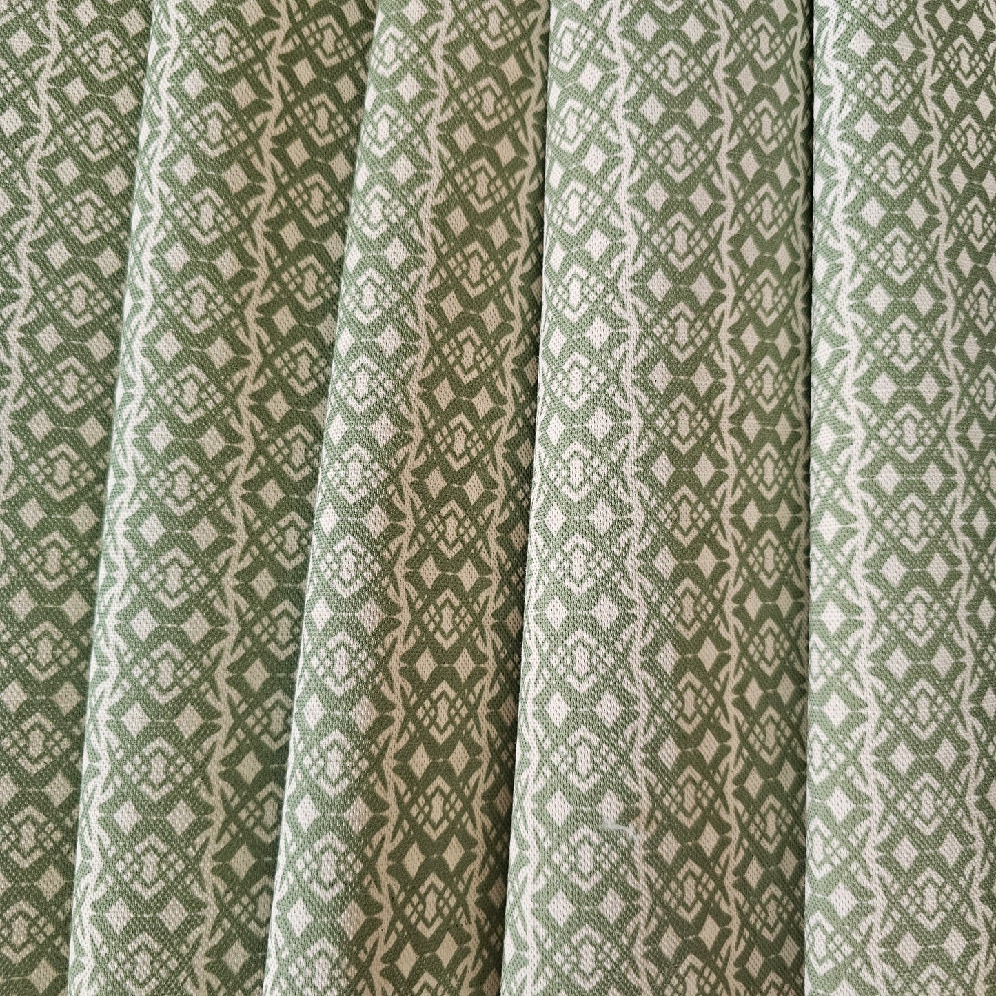 Fornet Classic cotton linen fabric swatch featuring a repeating green interlocking curved motif on an off‑white background. ZIA LIVING