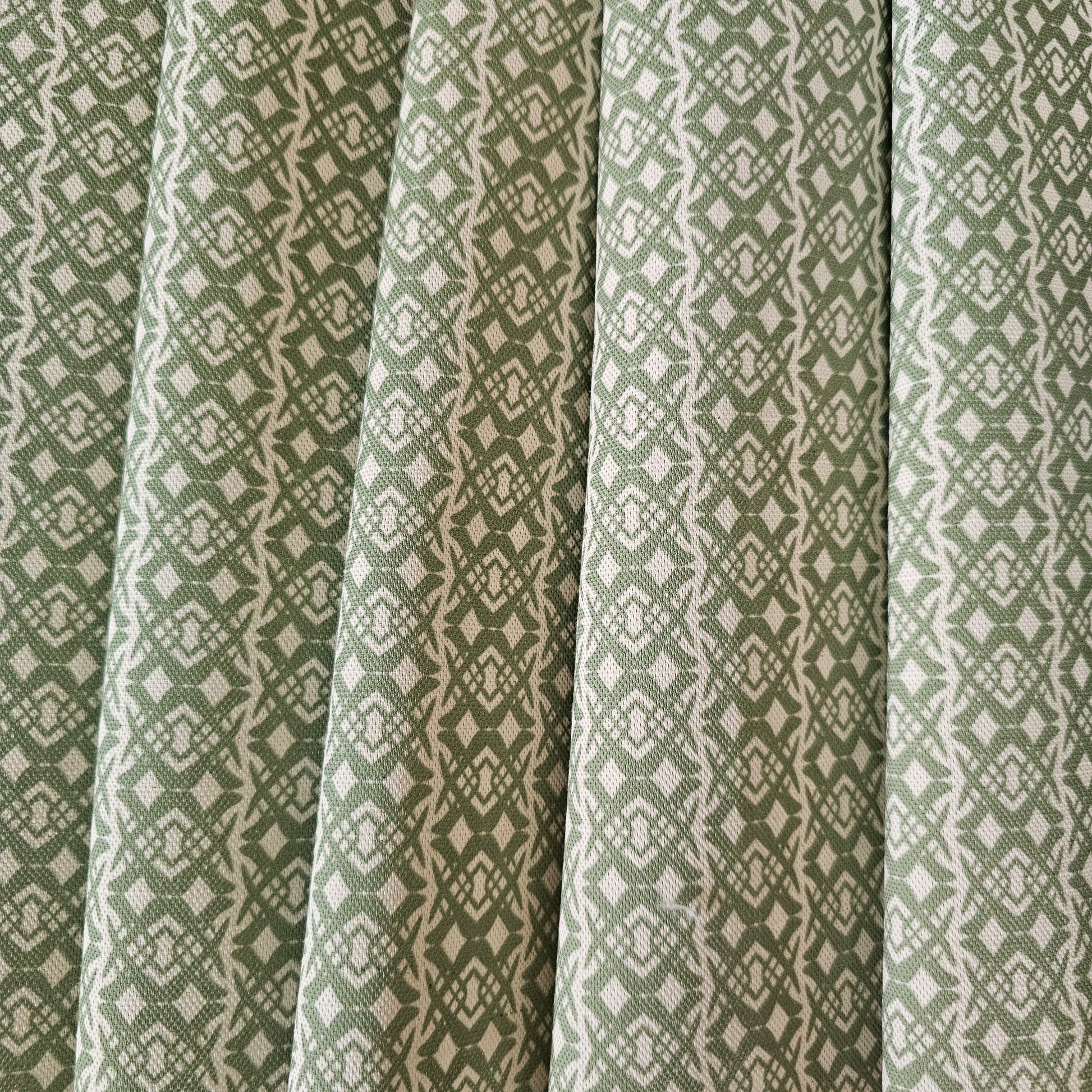 Fornet Classic cotton linen fabric swatch featuring a repeating green interlocking curved motif on an off‑white background. ZIA LIVING