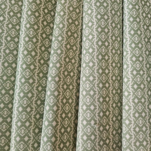 Fornet Classic cotton linen fabric swatch featuring a repeating green interlocking curved motif on an off‑white background. ZIA LIVING