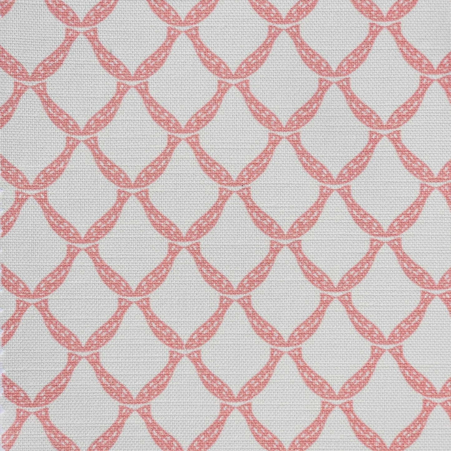 Marina cotton linen fabric featuring a repeating coral curved geometric trellis motif on an off‑white textured background. ZIA LIVING.
