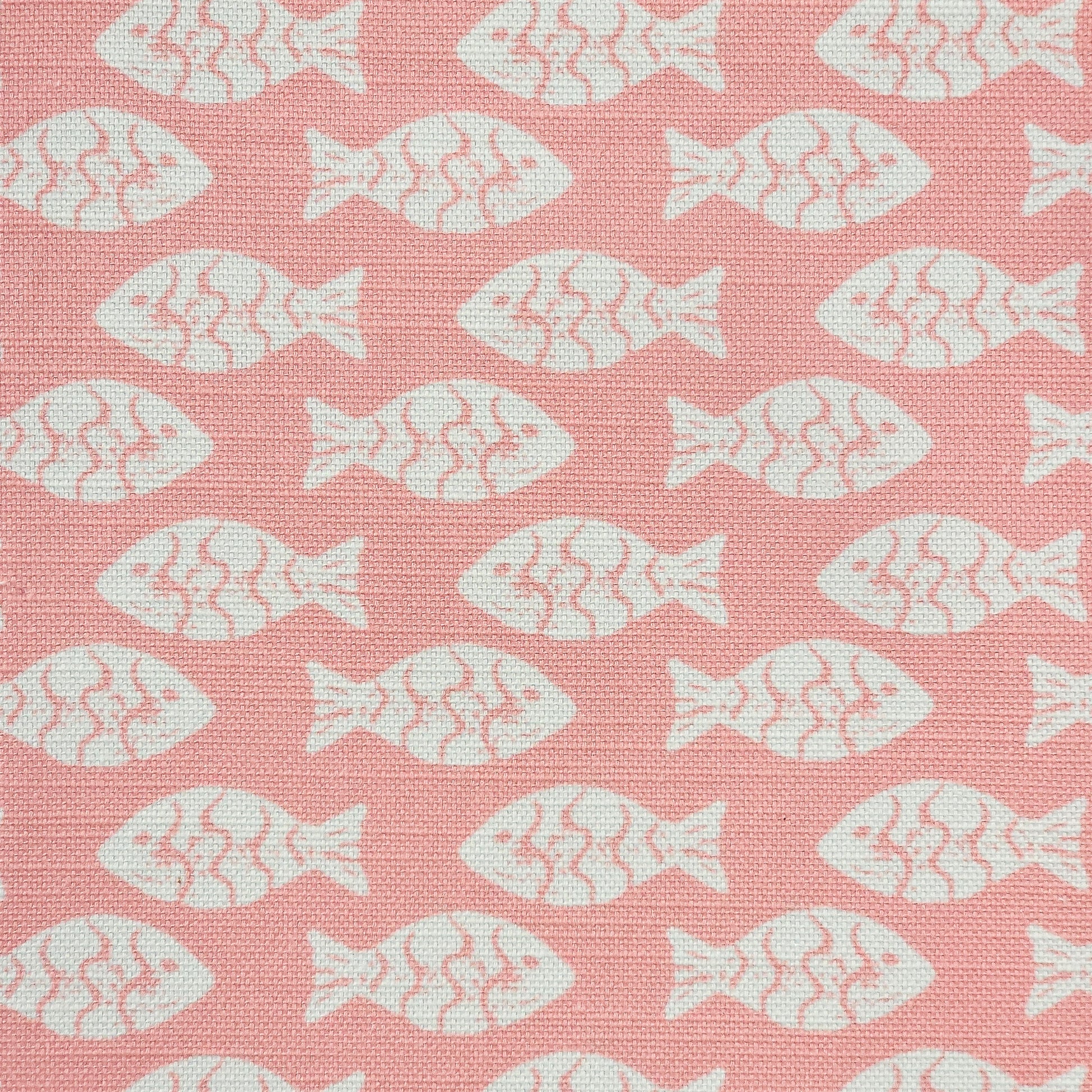 Shoal block‑print cotton linen fabric in off white featuring alternating stylised small fish motifs on an coral coloured background. ZIA LIVING.