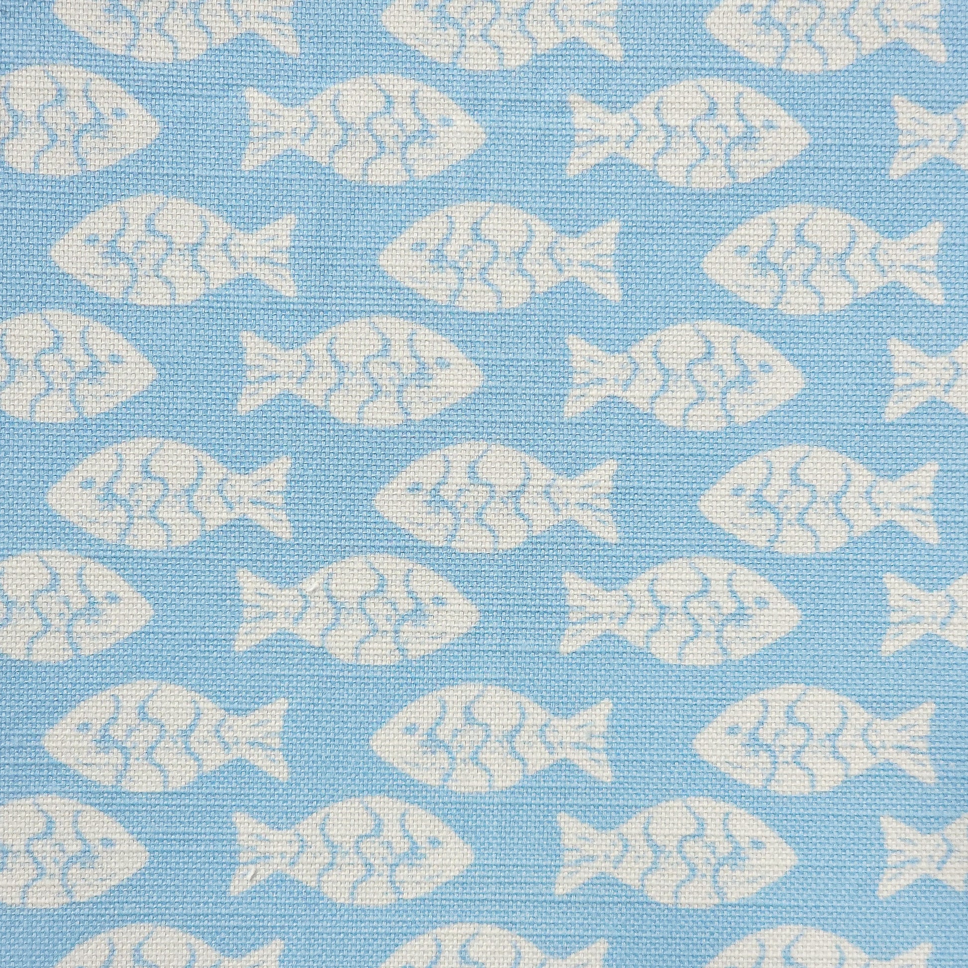 Shoal block‑print cotton linen fabric in off white featuring alternating stylised small fish motifs on an sky blue coloured background. ZIA LIVING.