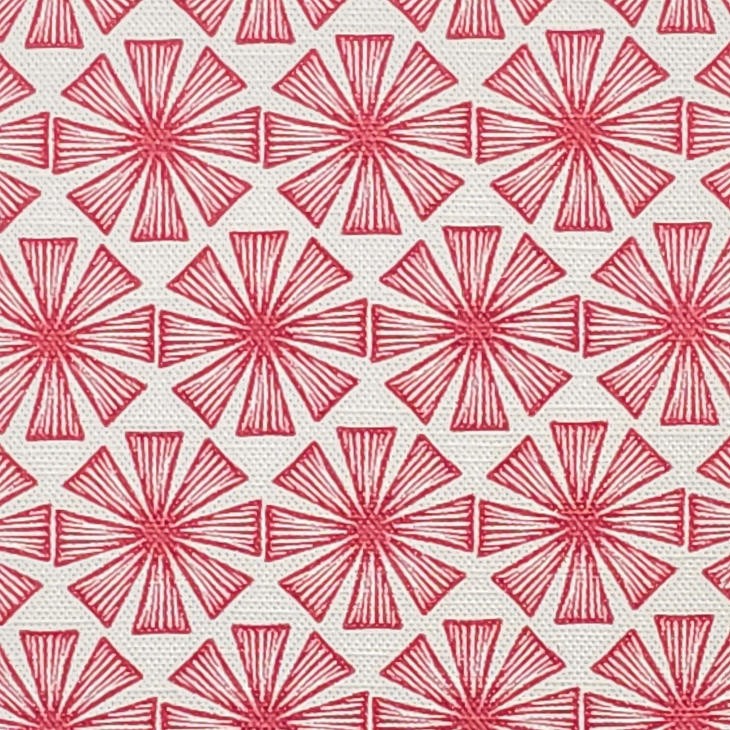 Stella cotton linen fabric featuring a bold red radiating motif in a repeating geometric pattern on an off‑white background. ZIA LIVING.