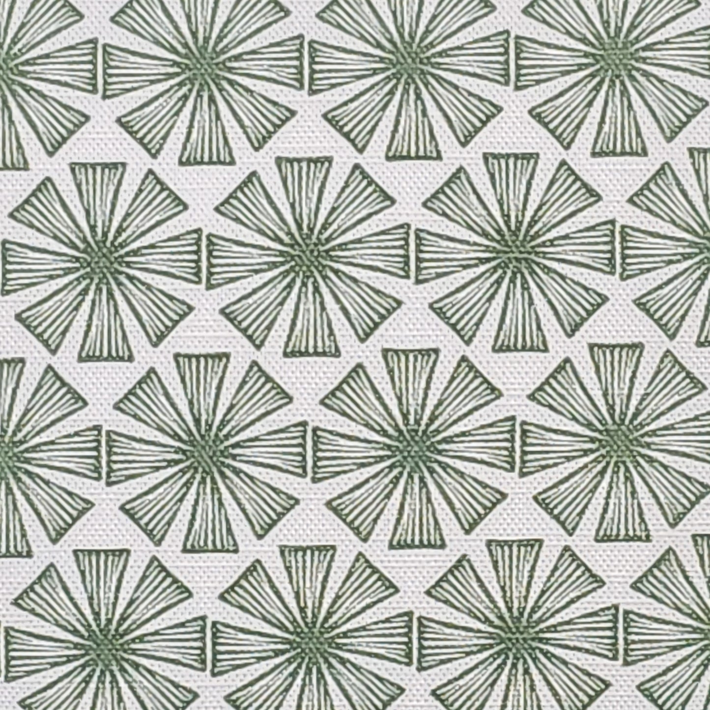 Stella cotton linen fabric featuring a bold green radiating motif in a repeating geometric pattern on an off‑white background. ZIA LIVING.