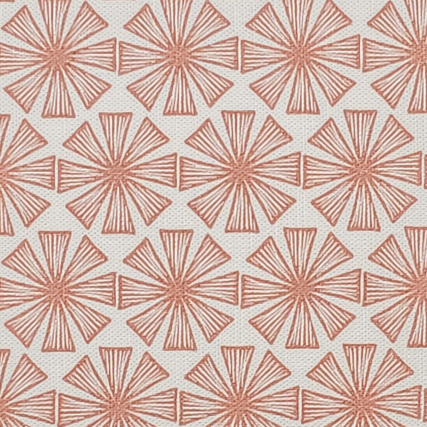 Stella cotton linen fabric featuring a muted peach coloured bold radiating motif in a repeating geometric pattern on an off‑white background. ZIA LIVING.