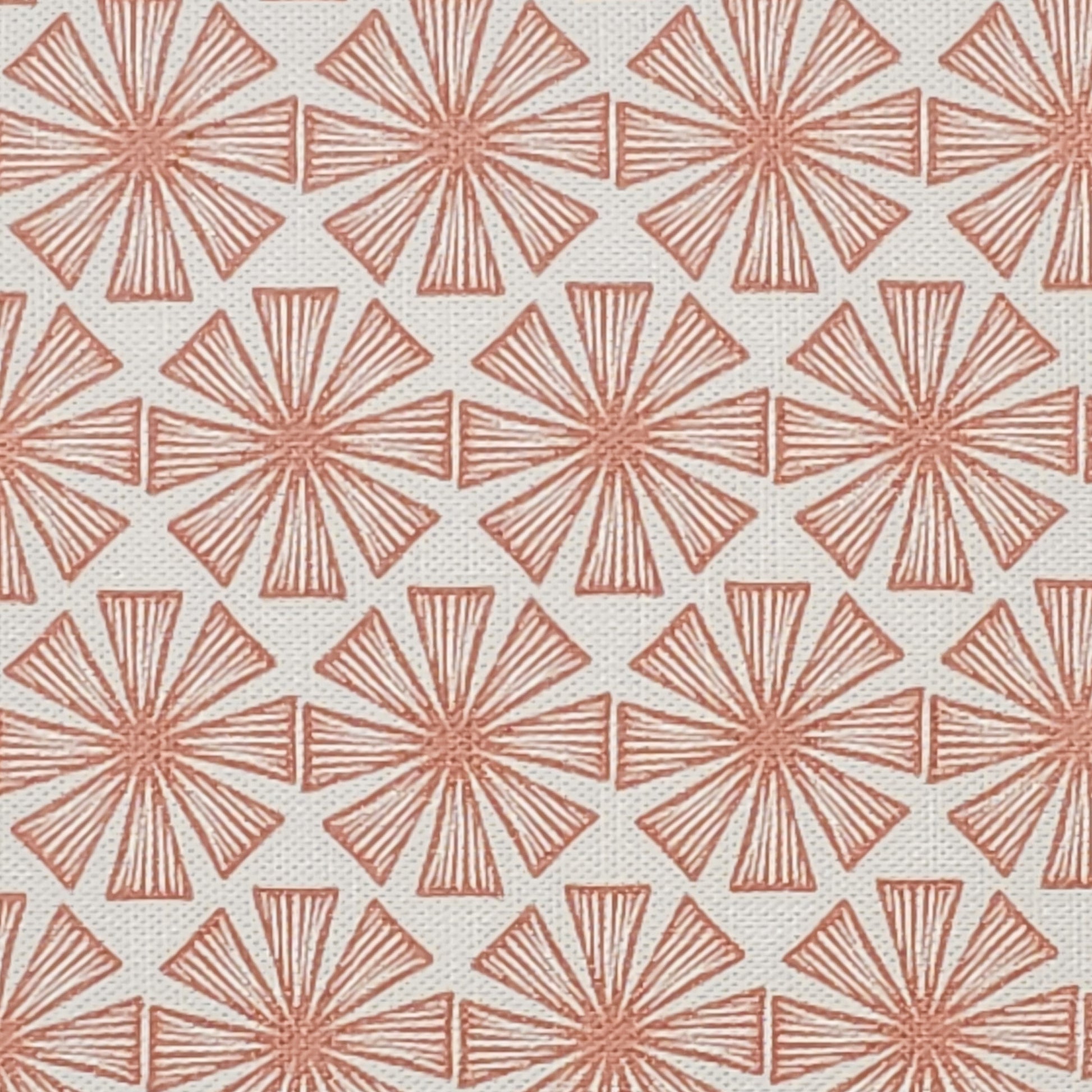 Stella cotton linen fabric featuring a muted peach coloured bold radiating motif in a repeating geometric pattern on an off‑white background. ZIA LIVING.
