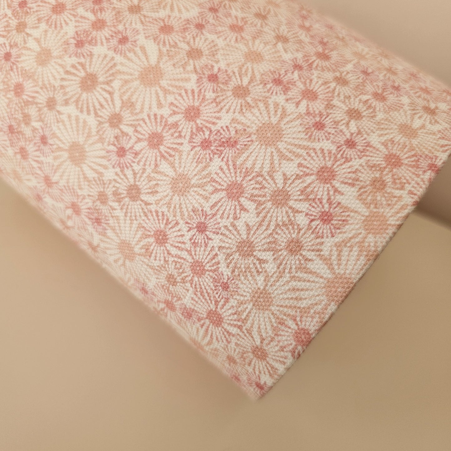 An oval lampshade in a pink Daisy print floral print fabric close up on neutral background.