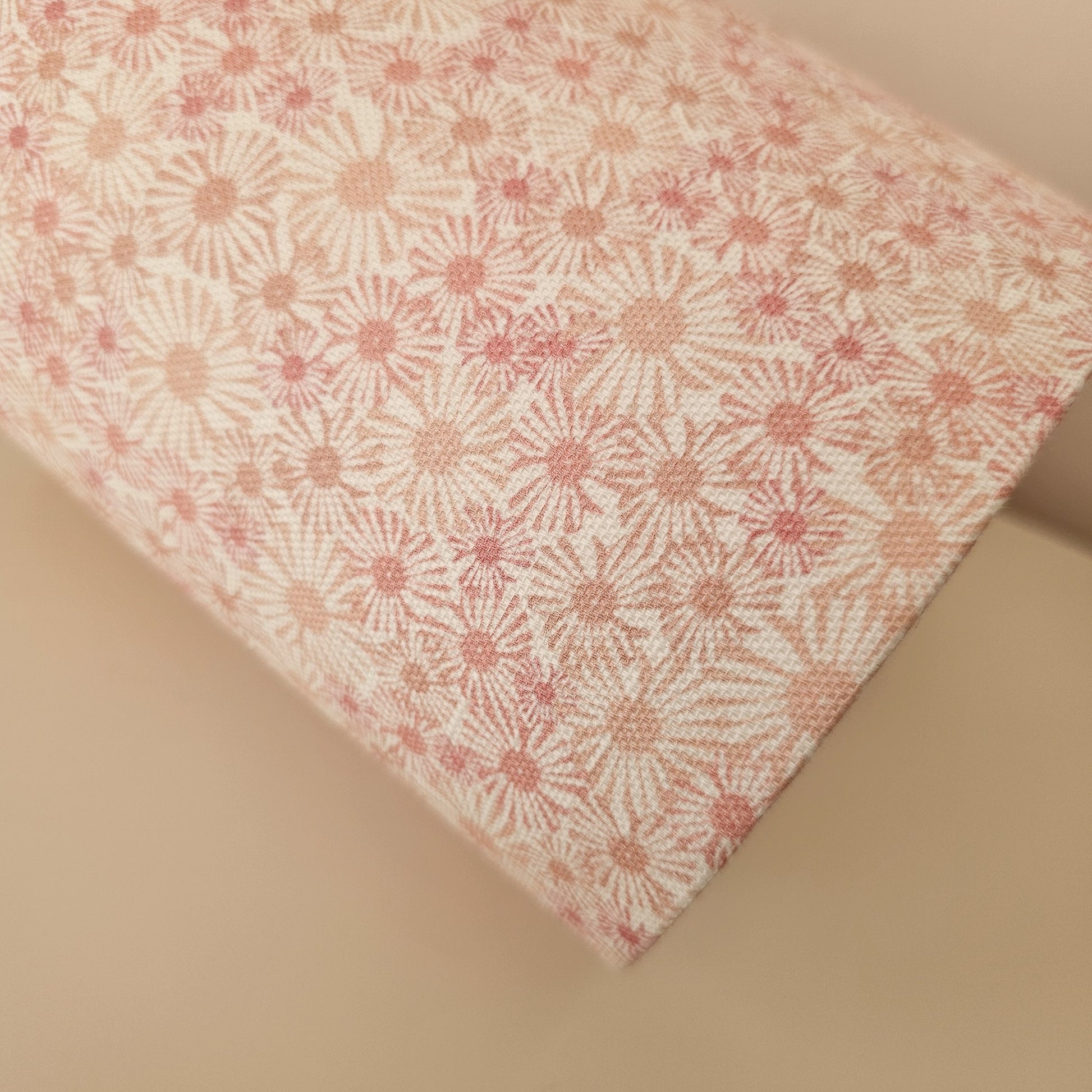 An oval lampshade in a pink Daisy print floral print fabric close up on neutral background.