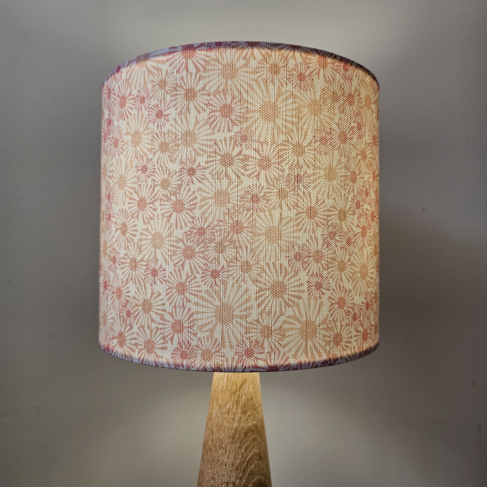 Daisy print drum lampshade with soft pink and beige floral motifs on a light background, lamp base- cosy setting — ZIA LIVING