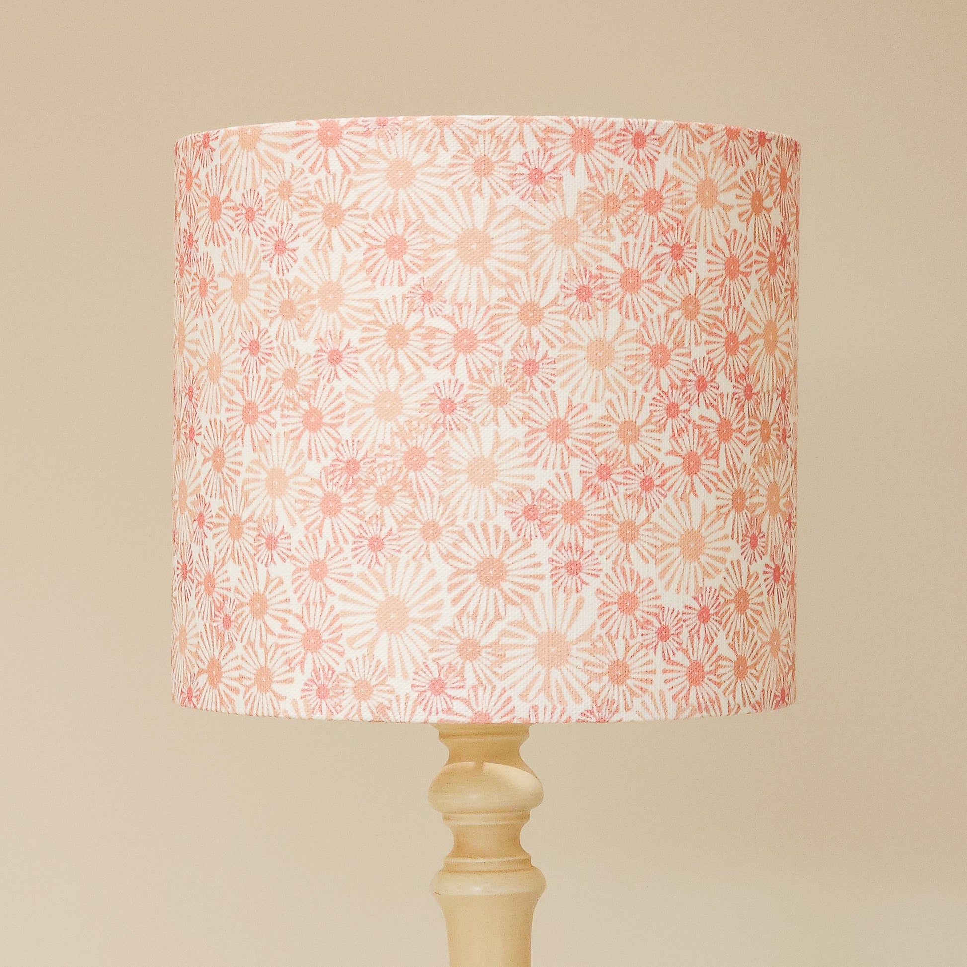 Daisy print drum lampshade with soft pink and beige floral motifs on a light background, styled on a neutral lamp base — ZIA LIVING