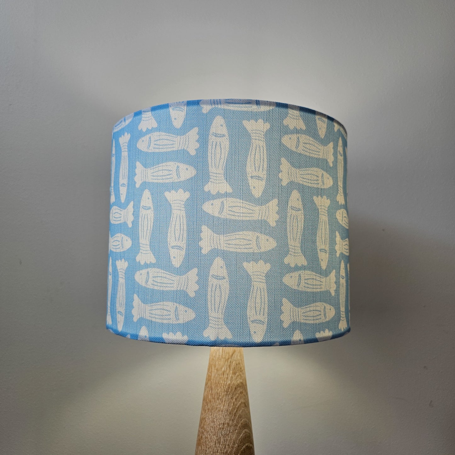 Zia Living Fishes lampshade lino print in sky blue on a lamp base - cosy setting