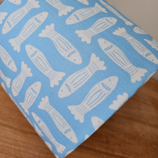 Zia Living Fishes fabric swatch lino print in sky blue with white fish featured on a drum lampshade close up