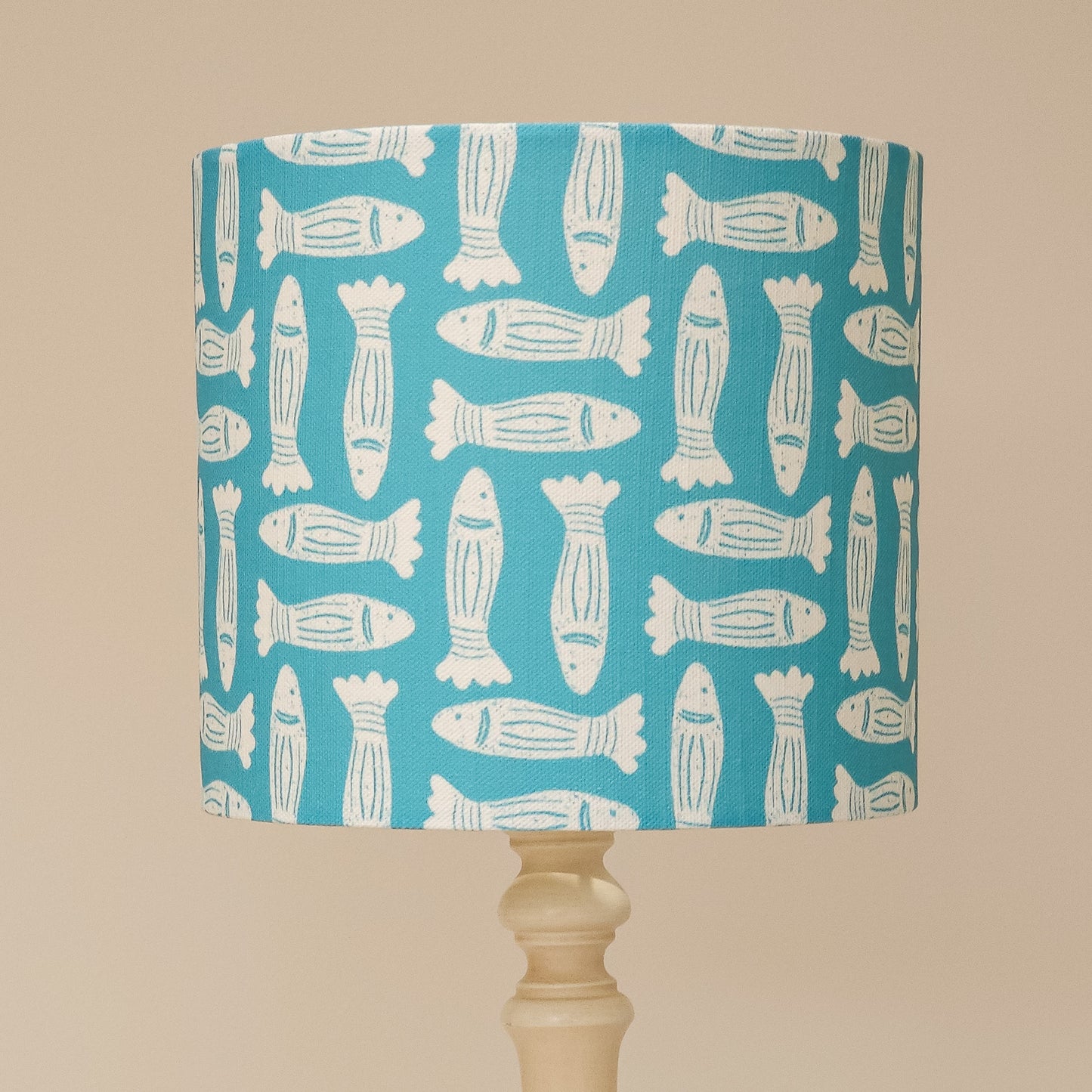 Zia Living Fishes lampshade lino print in teal on a lamp base