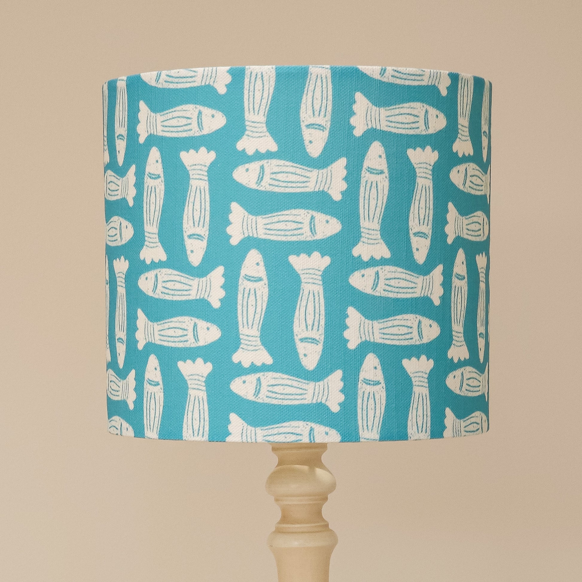 Zia Living Fishes lampshade lino print in teal on a lamp base