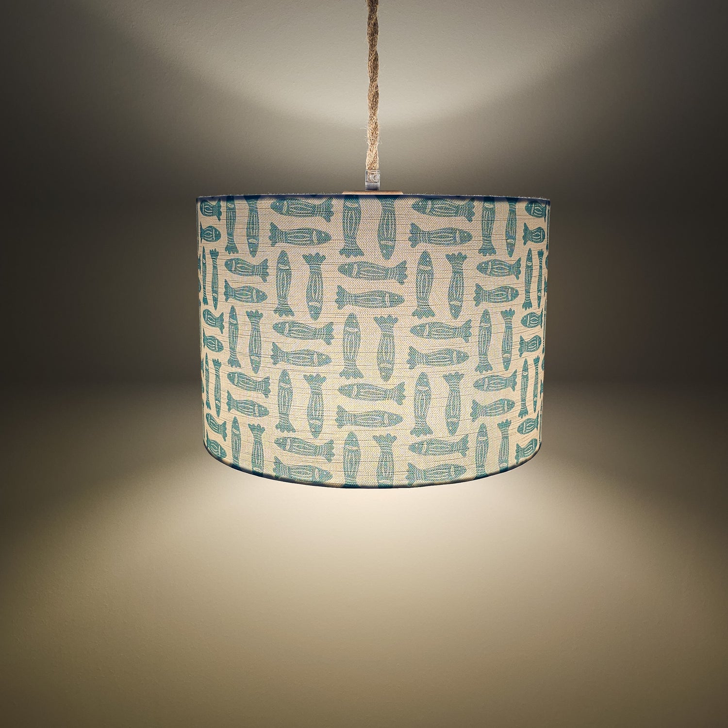 teal Fishes classic drum lampshade featuring simple hand‑drawn fish motifs on a warm neutral background, styled on a wooden surface — ZIA LIVING