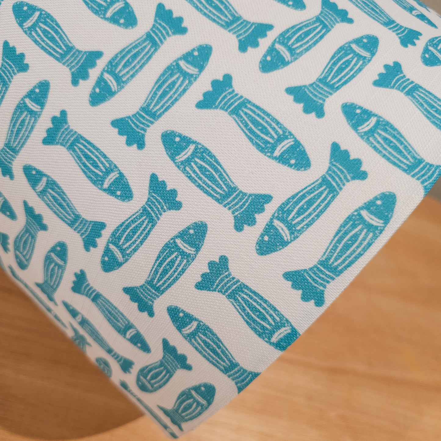 Teal Fishes drum lampshade featuring simple hand‑drawn fish motifs on a warm neutral background, styled on a wooden surface — ZIA LIVING