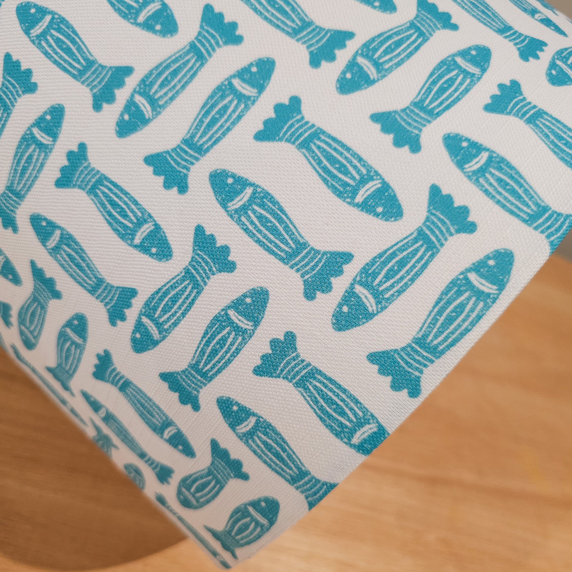 Teal Fishes drum lampshade featuring simple hand‑drawn fish motifs on a warm neutral background, styled on a wooden surface — ZIA LIVING