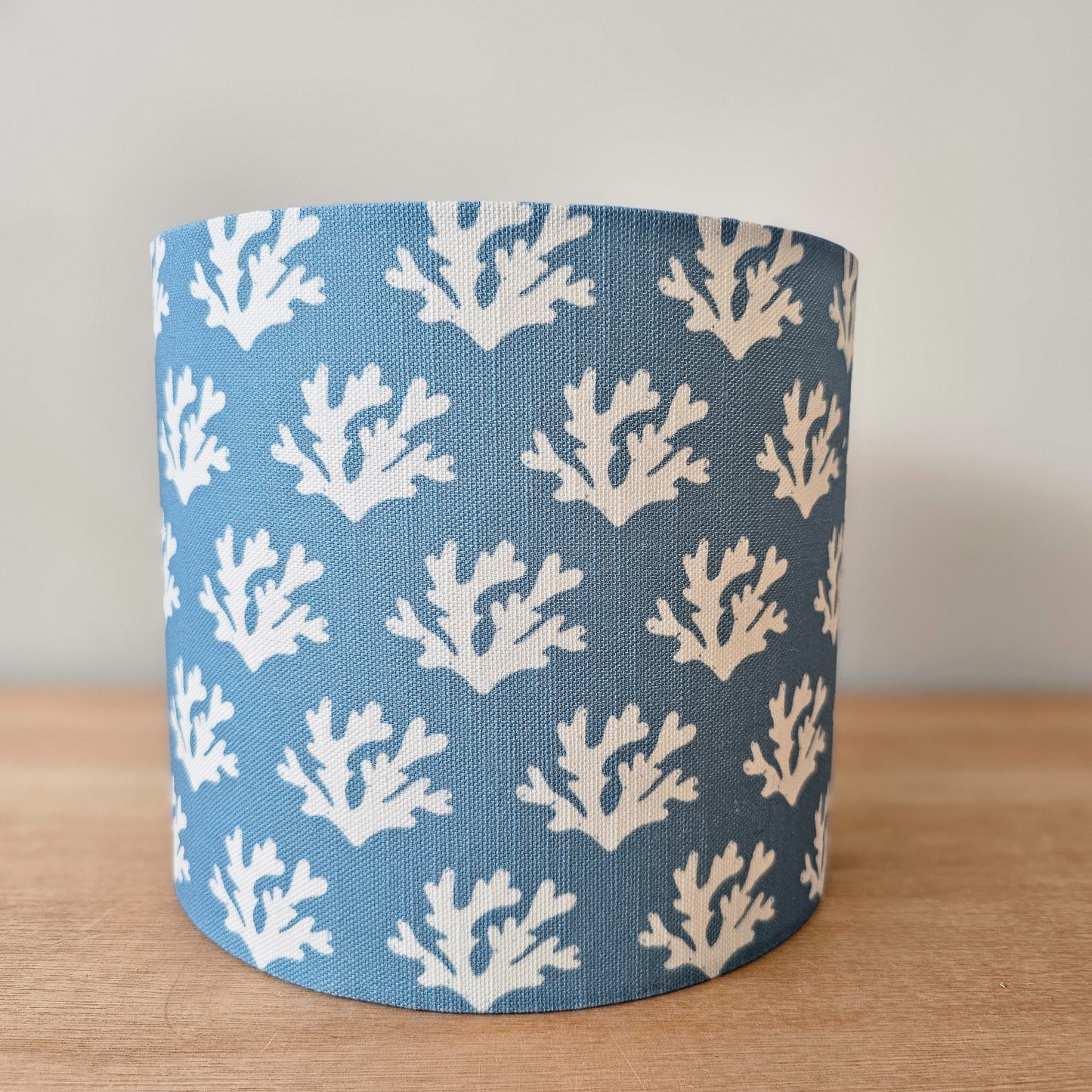 Zia Living Seaweed drum lampshade with white seaweed coral pattern on a blue background, front view. 