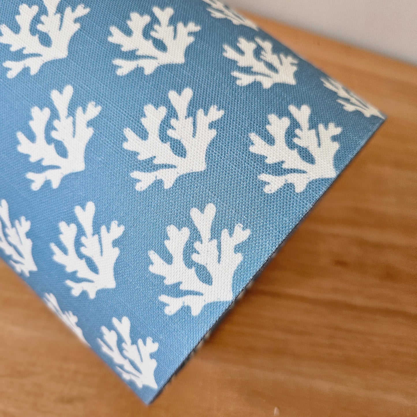Zia Living Seaweed drum lampshade with white seaweed coral pattern on a blue background., side view