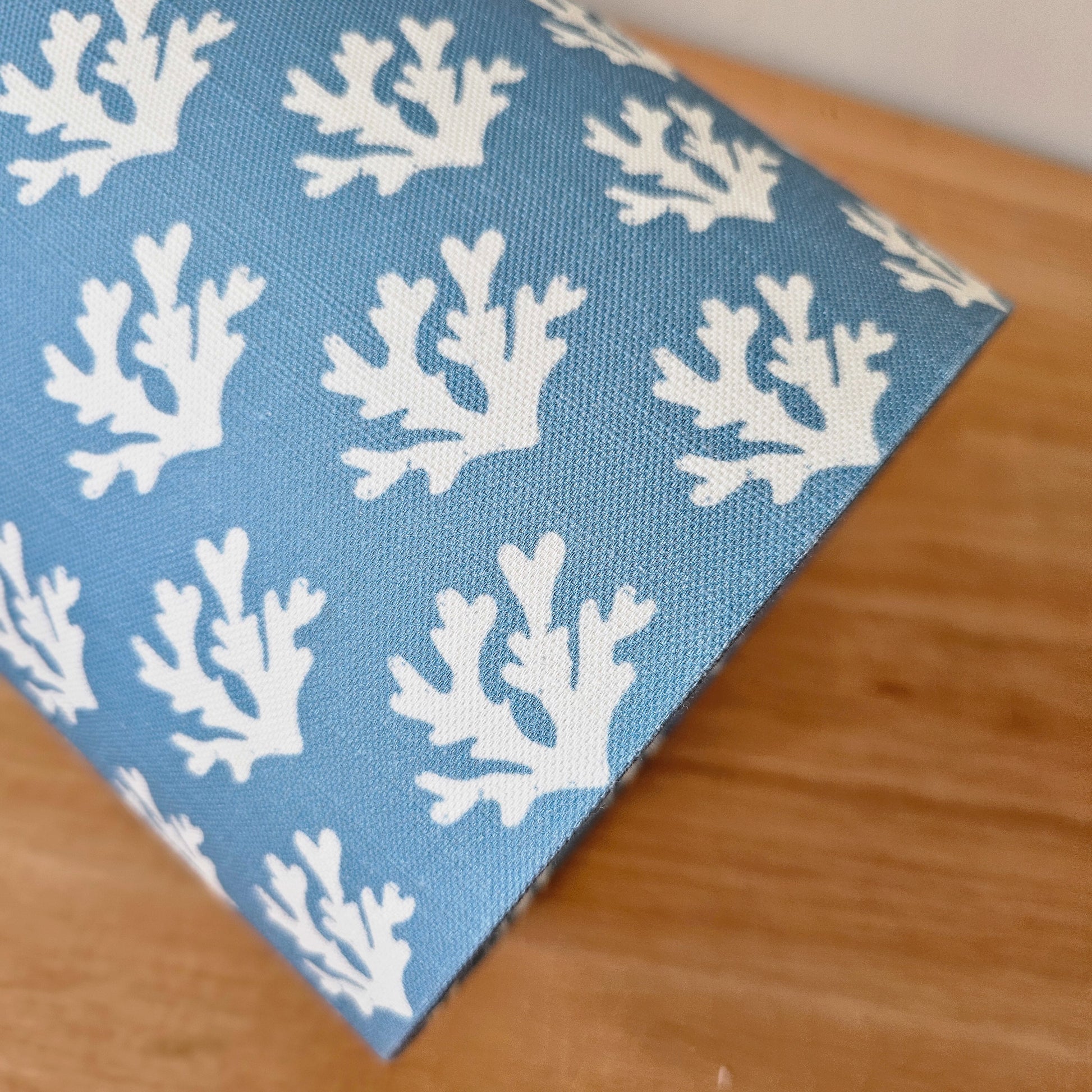 Zia Living Seaweed drum lampshade with white seaweed coral pattern on a blue background., side view