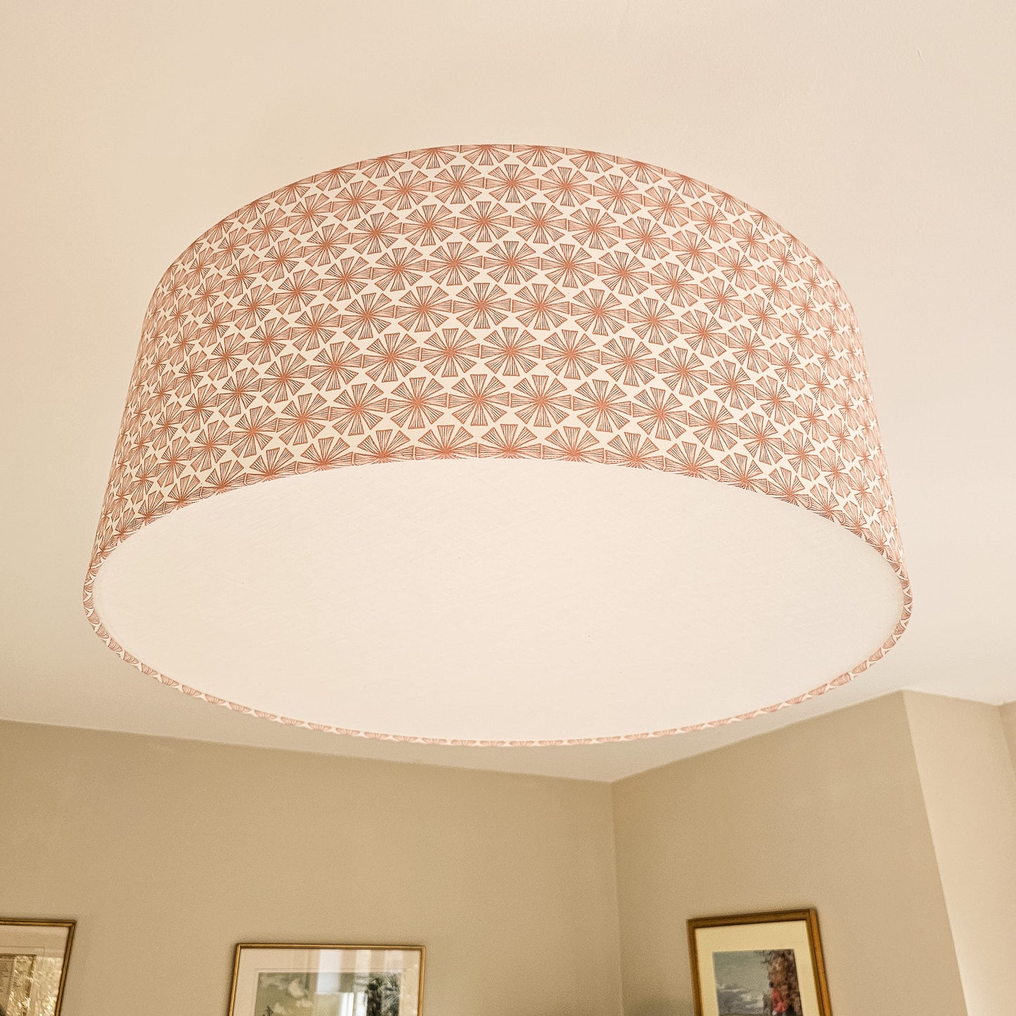 Stella cotton linen fabric featuring a peach coloured bold radiating motif in a repeating geometric pattern on an off‑white background, featured on a oversized lampshade ZIA LIVING.