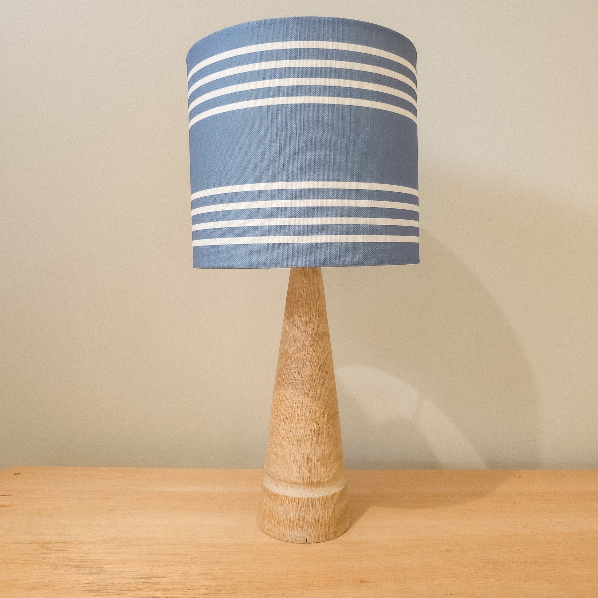 Drum lampshade in Blue Studio Stripe fabric on a wooden lamp base, horizontal stripe pattern — artisan home décor by ZIA LIVING.