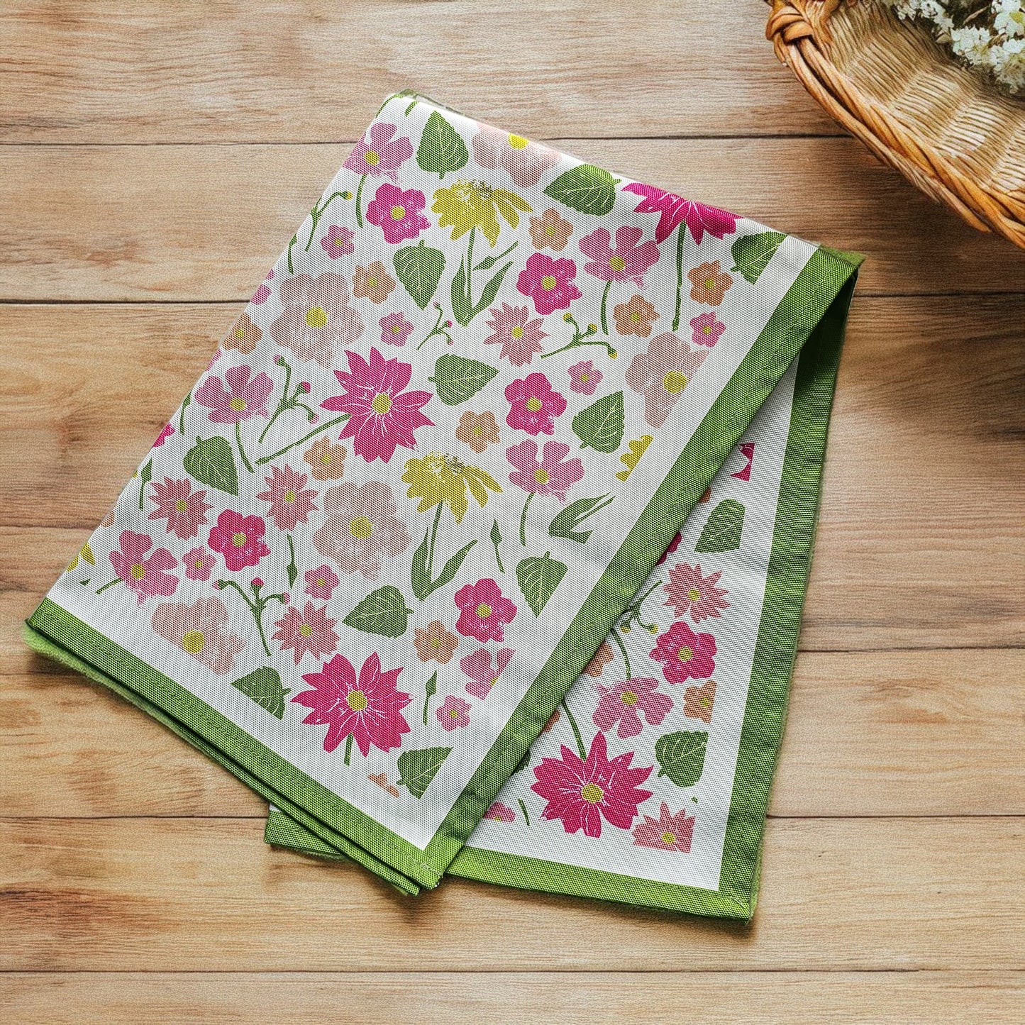 Floral sumer garden print tea towel from Zia Living with green border on a wooden surface