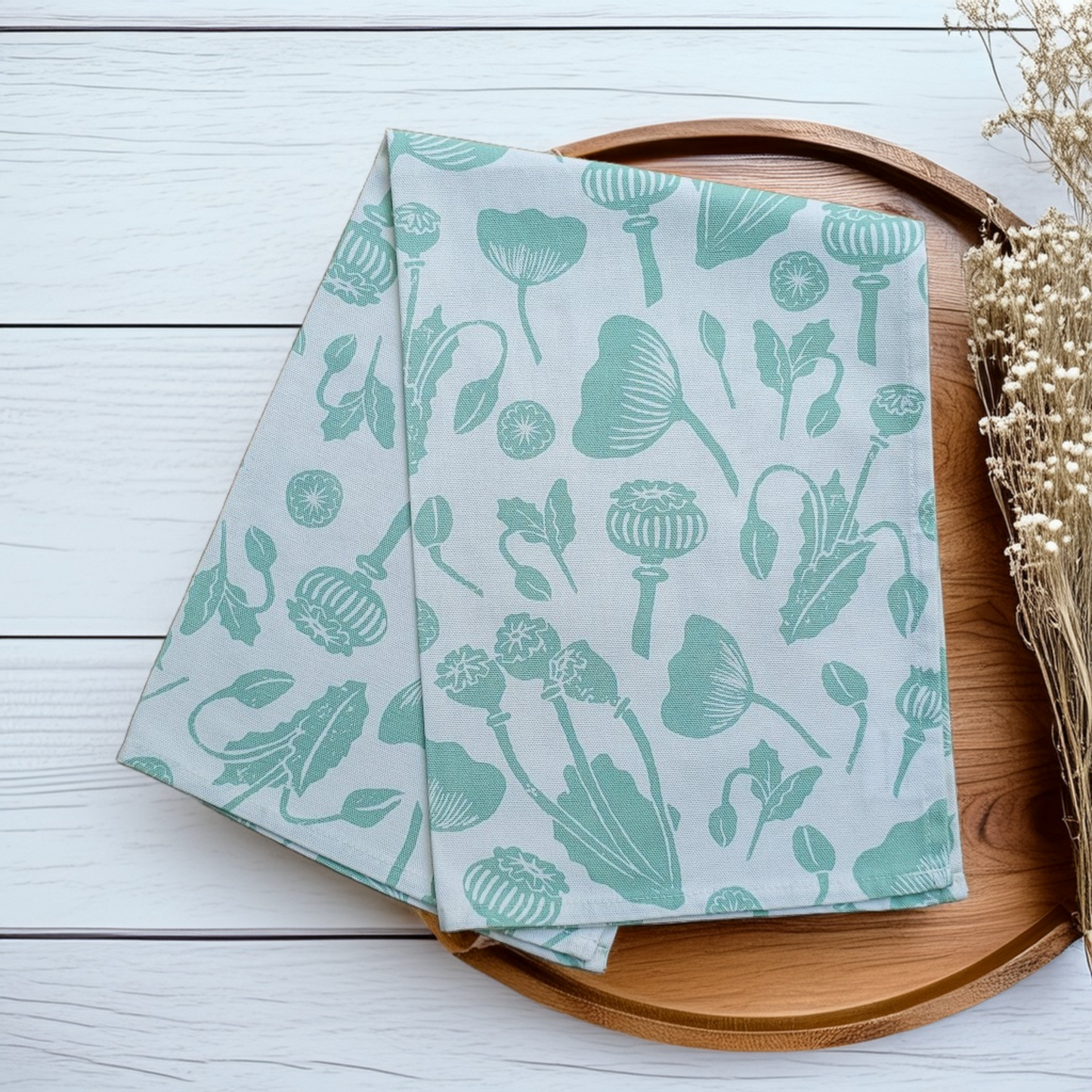 Tea towel with green floral pattern styled on a wooden tray. Zia Living